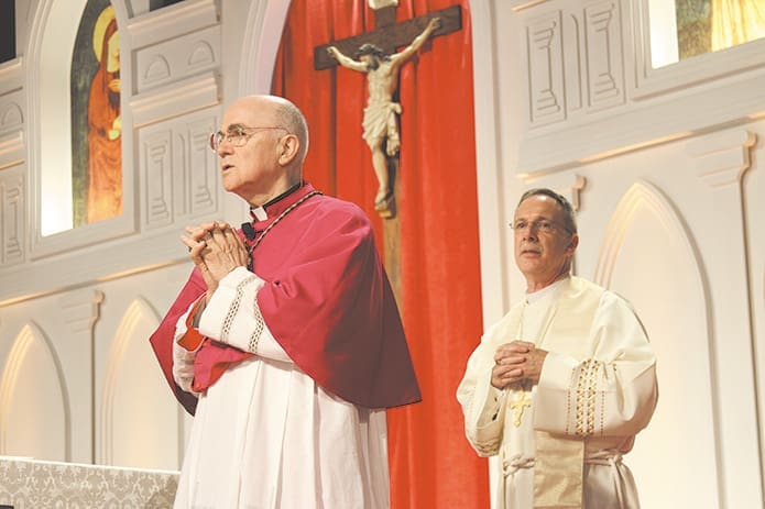 Archbishop Carlo Maria Vigano, apostolic nuncio to the United States, and Atlanta Auxiliary Bishop Luis Zarama stand at the altar as the monstrance holding the Blessed Sacrament is carried from the hall of the Georgia International Convention Center, College Park, site of the Archdiocese of Atlanta’s 2013 Eucharistic Congress. Photo by Michael Alexander