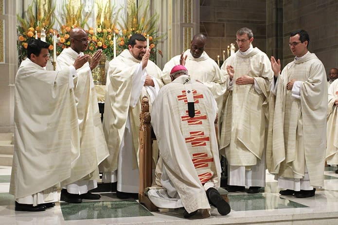 (Standing, l-r) Fathers Rey Pineda, Desmond Drummer, Luis Alvarez, Junot Nelvy, Matthew Dalrymple and Brian Baker extend a joint blessing to Archbishop Wilton D. Gregory, the rite of ordination to the priesthoodâs principal celebrant. The June 28 ordination took place at the Cathedral of Christ the King in Atlanta. Photo By Michael Alexander