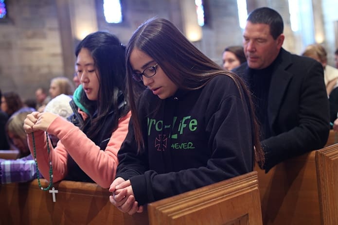 (L-r) Pinecrest Academy eighth-graders Eunji Cho and Daniela Callejas and Bruce Carlisle of St. Brendan the Navigator Church, Cumming, participate in the Rosary for Life at the Cathedral of Christ the King. Photo By Michael Alexander