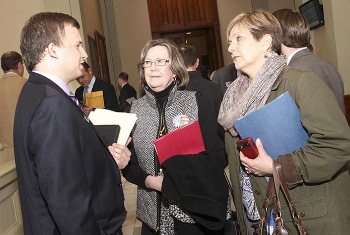 Standing the hall of the Georgia State Capitol, (r-l) Church of St. Ann parishioners Joey Minster and Lynn Sandes speak with 21-year-old Will Kremer, a legislative aide for state representative Trey Kelly of Cedartown. Photo By Michael Alexander