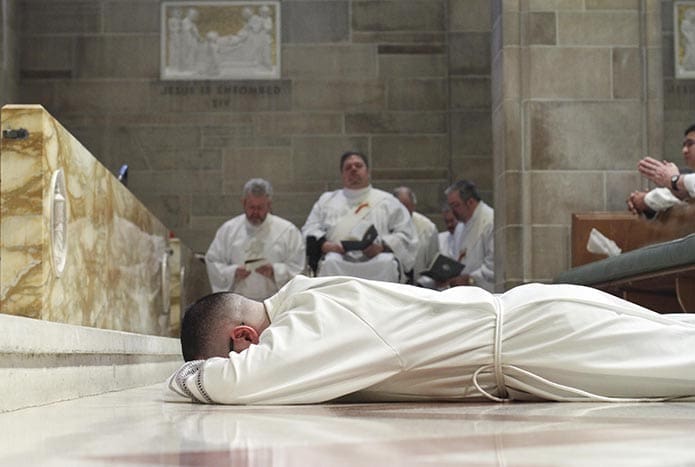Transitional deacon candidate Jorge Carranza lies prostrate along the center aisle of the Cathedral of Christ the King, Atlanta. Carranza was ordained to the diaconate with 12 permanent deacon candidates on Feb. 7. Photo By Michael Alexander