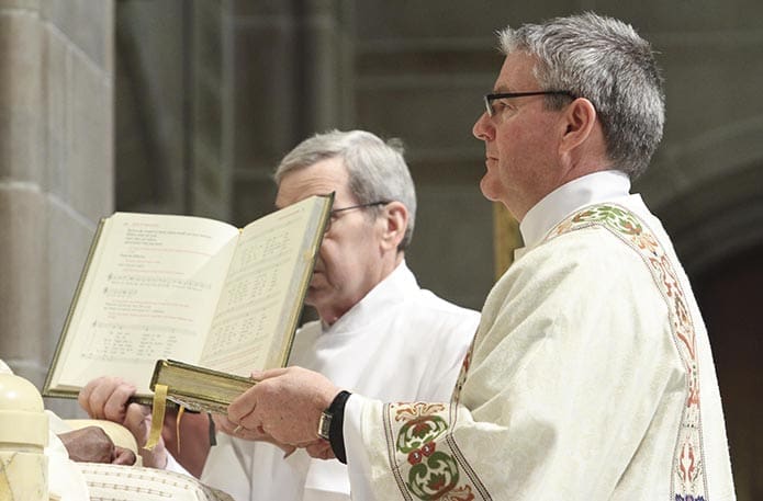 Archbishop Gregory presents the Book of Gospels to Deacon Brian Campbell. Deacon Campbell is assigned to serve at St. Brigid Church, Johns Creek. Photo By Michael Alexander