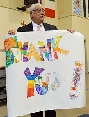 Charles Prejean, retiring director of the Office for Black Catholic Ministry, thanks the audience for the banner presented to him at the MLK Jr. Youth Celebration at St. Peter Claver School, Decatur. PHOTO BY LEE DEPKIN