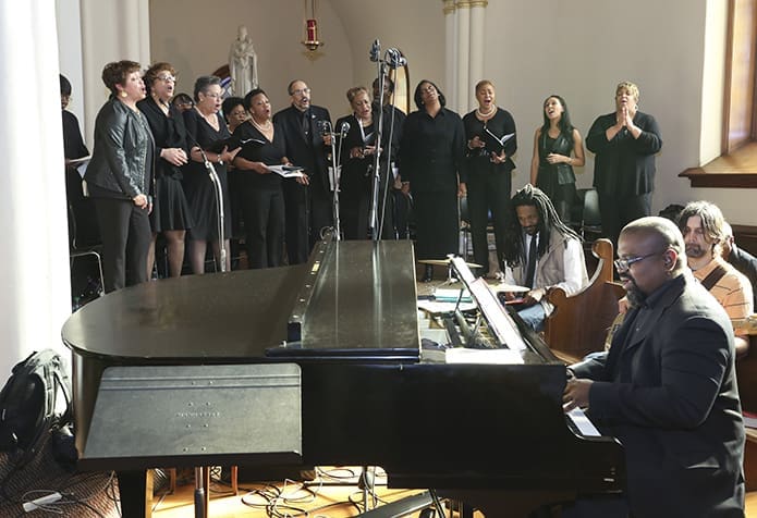 The St. Anthony of Padua Church choir, under the direction of John Beal, seated at the piano, sings the offertory hymn, âMy God Is Awesome.â Photo By Michael Alexander
