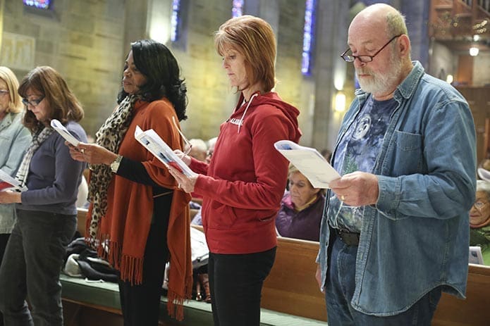 (R-l) Mike Cribbs of Our Lady of the Assumption Church, Atlanta, Mary Jo Mirynowski of St. Brendan the Navigator Church, Cumming, and Linda Harrison of Holy Family Church, Marietta, stand before the Cathedral of Christ the King congregation during the commissioning of respect life leaders. Photo By Michael Alexander