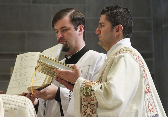 Thirty-two-year-old Rev. Mr. Roberto SuÃ¡rez, right, receives the Book of Gospels from the archbishop. SuÃ¡rez will be at St. Joseph Church in Athens during his assignment as deacon. Photo By Michael Alexander