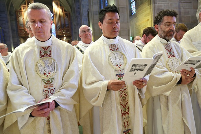 (L-r) Father Paul Williams, pastor of St. Joseph’s Church, Dalton, Father Rafael Castaño, pastor of Sacred Heart of Jesus Church, Hartwell, and Father Rafael Carballo, pastor of Our Lady of Perpetual Help Church, Carrollton, participate in the renewal of priestly commitment with their brother priests during the annual Chrism Mass. Photo By Michael Alexander