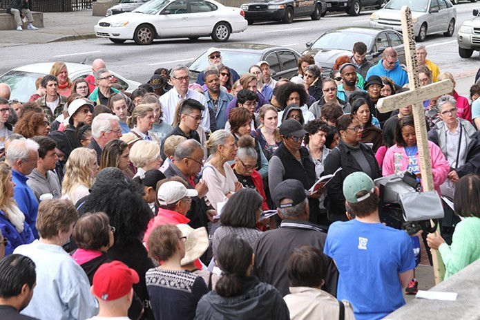 The crowd of Good Friday Pilgrimage participants gather in front the Fulton County Courthouse as they listen to a tearful reflection on child sex trafficking during the fourth Station of the Cross (Jesus meets his mother). Photo By Michael Alexander