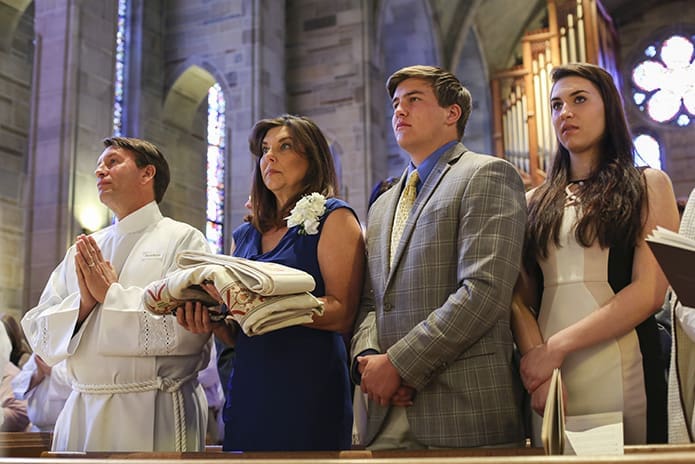 (L-r) David Barron, a permanent diaconate candidate from Holy Family Church, Marietta, is joined in the pew by his wife Michelle, his 21-year-old son John and his 18-year-old daughter Haille. Photo By Michael Alexander