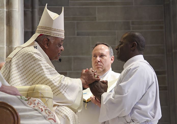 Kapya Muzinga Ngoy of Saint Marguerite D'Youville Church, Lawrenceville, pledges his obedience to Archbishop Wilton D. Gregory and his successors. Ngoy was one of two permanent diaconate candidates from his parish to be ordained at the Cathedral of Christ the King, Atlanta, Feb. 5. Photo By Michael Alexander