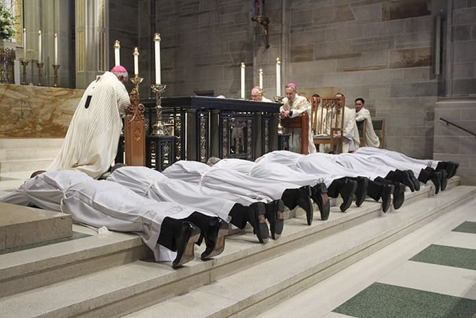 All eight diaconate ordination candidates prostrate themselves across the altar during the Feb. 6 rite of ordination to the diaconate. Photo By Michael Alexander