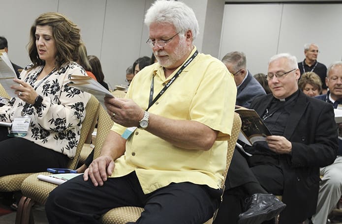 Conference participants like (l-r) Amy Jackson of St. Mary of the Woods Church, Whitesville, Ky., Barry Kolbeck of Holy Spirit Church, Sioux Falls, S.D., and Father Gary Linsky, pastor of St. Peter Church, Columbia, S.C., join others in praying the stewardship prayer at the outset of the morning workshop session. The prayer was a contribution to the International Catholic Stewardship Council from Msgr. Anthony Marcaccio, pastor of St. Pius X Church, Greensboro, N.C. Photo By Michael Alexander