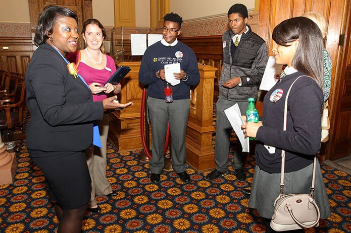 (Counterclockwise, from left) District 43 State Senator Tonya Anderson speaks with Cristo Rey Atlanta Jesuit High School student Monica Epps, Kathy Montag, Catholic Relief Services capacity building specialist, Cristo Rey Atlanta students Malcolm Delfish and Jahari Fraser, and the school’s religion instructor and campus minister Bernadette O’Neill. Photo By Michael Alexander