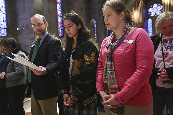 (L-r) Brian Freel, director of campus ministry at Marist School, Atlanta, sophomore student leader Lindsey Reina, and Pamela Kinzly, mathematics teacher and moderator for the school’s life, dignity and justice group, stand before the altar as they are commissioned as respect life leaders. Photo By Michael Alexander