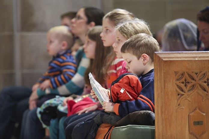 Four-year-old Stefano West, foreground, joins his other five siblings on the pew during the Jan. 23 Mass for the Unborn at the Cathedral of Christ the King, Atlanta. His mother Michelle is scheduled to give birth to the family’s seventh child this coming June. Photo By Michael Alexander