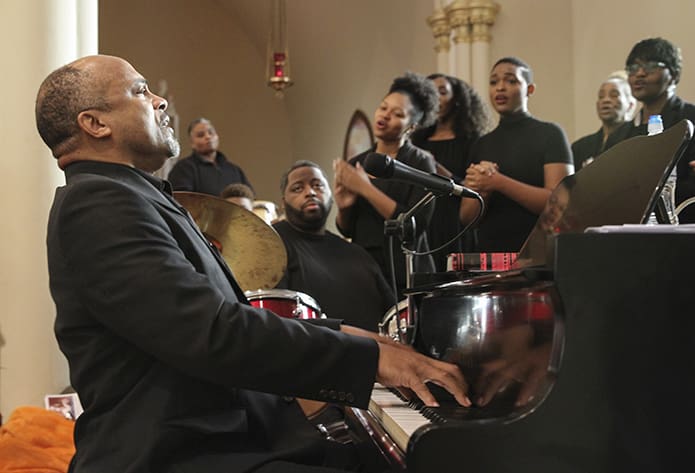 Dr. Kevin Johnson, foreground, the director of music and liturgy at Lyke House, the Catholic Center at the Atlanta University Center, leads the Lyke House Mass Choir in singing “We Shall Overcome” and “Keep the Faith.” Photo By Michael Alexander