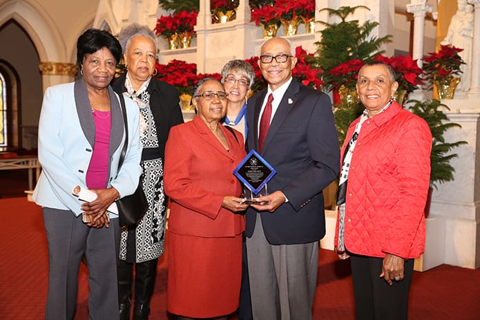Suchet Loois, Ph.D., and his wife Mathilde hold the Charles O. Prejean, Sr. Unity Award he received during this year’s Mass. Standing with Loois are fellow members of the Martin Luther King Jr. outreach group at his parish St. Pius X Church, Conyers. They include (l-r) Marie Noel, Patricia Barnes, Delores Dean and Yvonne Lee. Photo By Michael Alexander