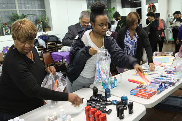 (L-r) Mattie Nunnally of Atlanta, Ashley Moore, a senior at St. Pius X High School, Atlanta, and Trish Dykes, a fourth-grade teacher at St. Joseph School, Marietta, file through in an assembly line fashion colleting items for hygiene kits to be donated to St. Vincent de Paul Georgia and the Shrine of the Immaculate Conception’s St. Francis Table Ministry. Photo By Michael Alexander