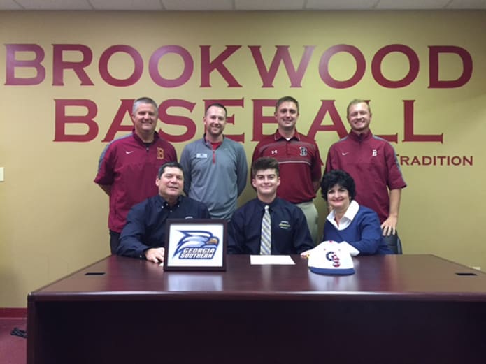 Sitting between his parents Terry and Janine, Austin Hohm, front row center, of Brookwood High School, Snellville, signed to play baseball at Georgia Southern University, Statesboro. Standing behind them are (l-r) Brookwood coaches Roger Parham, Zach Shellnutt, Titus Martin and Jason Hughes. Hohm is a member of St. John Neumann Church in Lilburn.