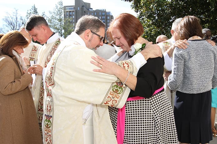 Newly ordained permanent deacon Randall Ory of St. Oliver Plunkett Church, Snellville, center, extends a blessing to his spouse, Lynn, of 38 years on the Cathedral of Christ the King plaza following the Feb. 4 rite of ordination to the permanent diaconate. Deacon John Martin of Our Lady of the Americas Mission, Lilburn, left, and Deacon Erik Wilkinson of Immaculate Heart of Mary Church, Atlanta, right, also do the same for their respective wives, Mary and Nancy Sestak. Photo By Michael Alexander