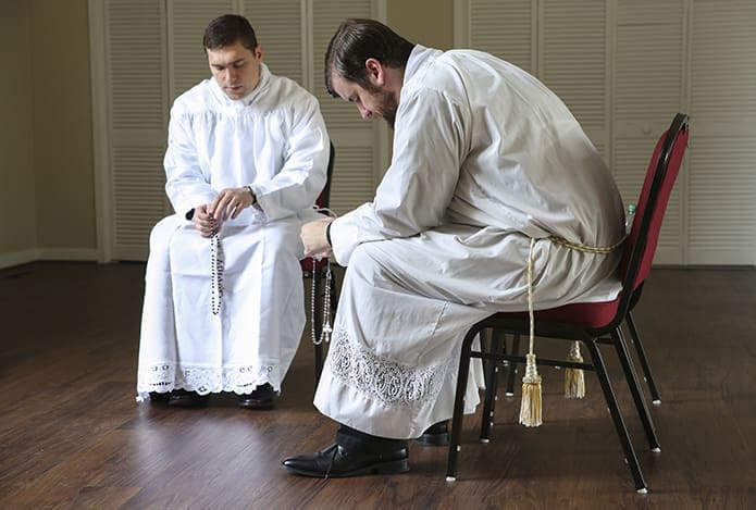 In the solitude of the ministry offices building at the Cathedral of Christ the King, Atlanta, Rev. Mr. Bryan Kuhr, left, and Rev. Mr. Bradley Starr pray the Joyful Mysteries of the rosary before their June 24 ordination to the priesthood. Photo By Michael Alexander