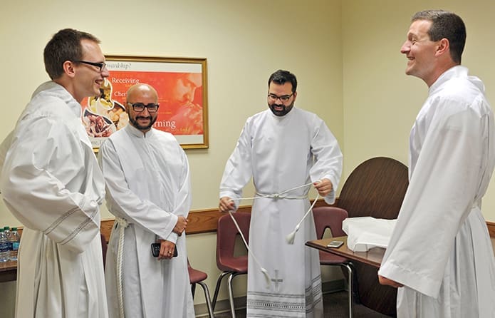 (L-r) Michael Bremer, Carlos Ortega, Jack Knight and Michael Metz vest downstairs at the Cathedral of Christ the King in preparation for their ordination Mass May 27.