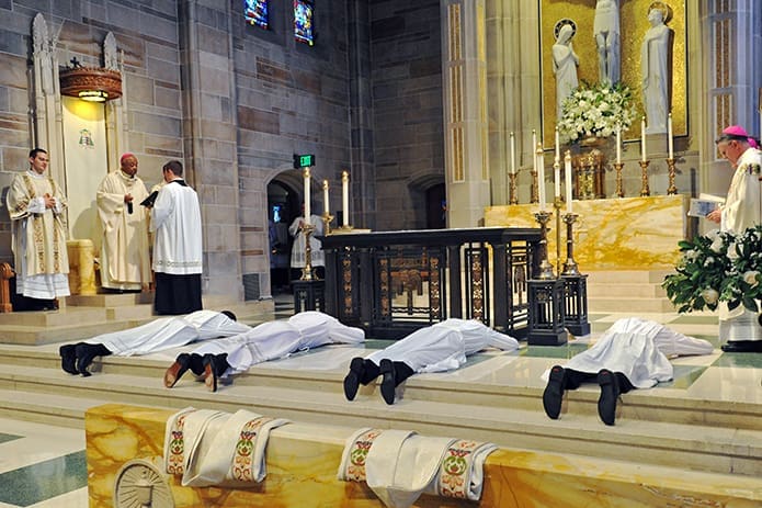 During the litany of supplication, the diaconate candidates lie prostrate on the altar. Concelebrants for the Mass of ordination May 27 with Archbishop Wilton D. Gregory were Bishop Luis R. Zarama and Archbishop Timothy P. Broglio, of the U.S. Archdiocese for the Military Services.