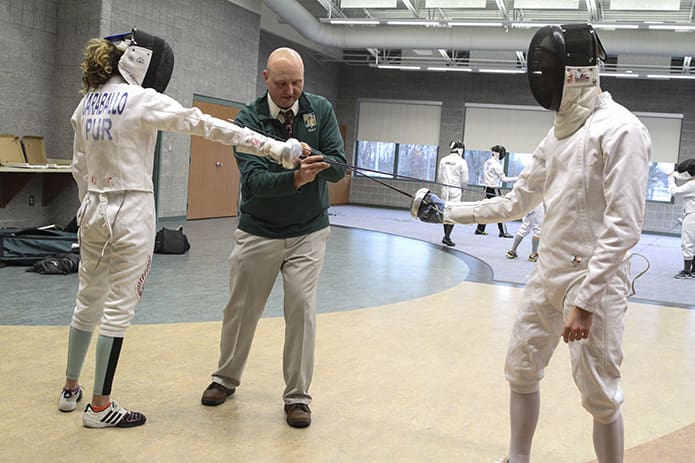 Coach Chad Morris goes over blade technique with senior fencers Isabella Caraballo, left, and Andrew Flowers. Caraballo and Flowers are this season's team captains. Photo By Michael Alexander