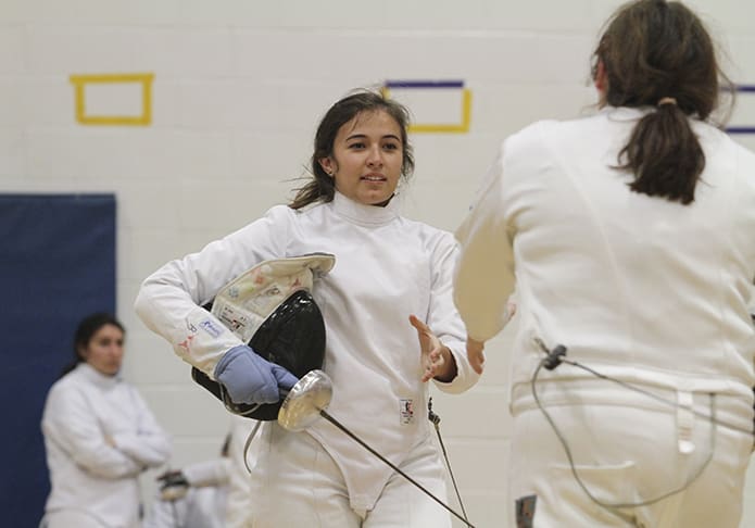 Pinecrest Academy senior fencer Juliana Jennings, center, shakes hands with her opponent after her fifth victorious bout during a tournament last December at Chattahoochee High School in Johns Creek. Jennings is one of eight female fencers set to compete in the individual fencing championship at Chattahoochee High School in Johns Creek on Jan. 26. Photo By Michael Alexander