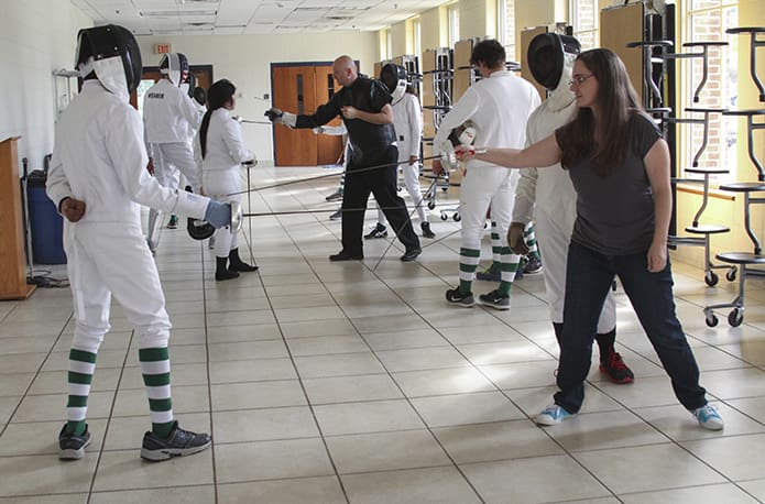 Assistant coach Deirdre Donlon, foreground right, and head coach Chad Morris, background right, lead the team in an exercise surrounding blade work. Photo By Michael Alexander