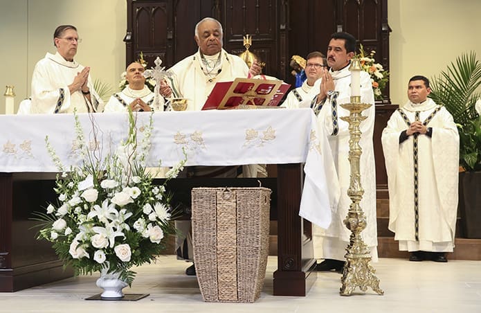 Archbishop Wilton D. Gregory, center, stands before the altar during the Liturgy of the Eucharist. Those on the altar with him include (l-r) Deacon Ken Lampert, Father Hernan Quevedo, parochial vicar at St. John Paul II Mission, Father Timothy Hepburn, pastor of St. Michael Church, Gainesville, Deacon Jose Pineda and Father William Canales, administrator of St. John Paul II Mission. Photo By Michael Alexander