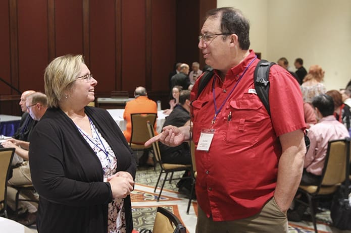 Kathy Leos of Dallas, Texas, left, and Father Glenn LeCompte, from the Diocese of Houma-Thibodaux (Louisiana), converse before the Oct. 3 study day begins at the National Meeting of Diocesan Liturgical Commissions. Photo By Michael Alexander