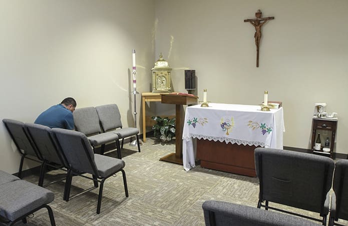 A man prays alone in the chapel before the Oct. 28 Mass of Dedication begins at St. Clare of Assisi Church in Acworth. Photo By Michael Alexander
