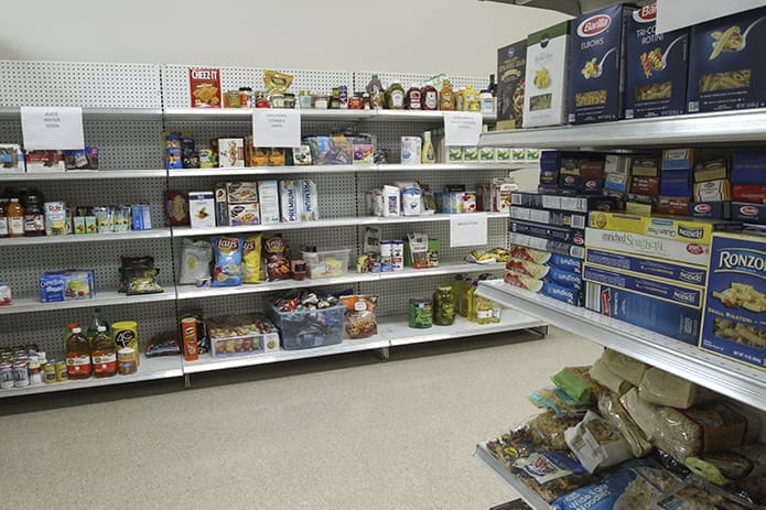 Various labeled food items are displayed on the shelves of the food pantry at St. Michael the Archangel Church, Woodstock. The new facility officially opened for distribution of food on Nov. 10. Photo By Michael Alexander