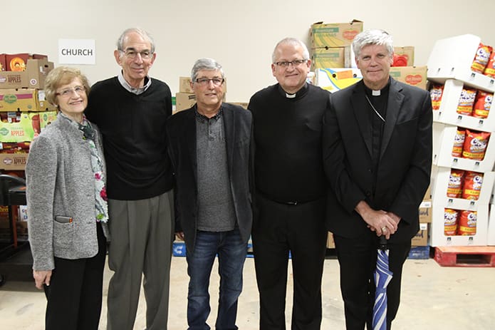 After the formal dedication, Mike Minnick of A1 Construction, center, the general contractor for the new food pantry, poses for a photograph with (l-r) food pantry managers Susan and Sam Nappi, St. Michael the Archangel pastor Father Larry Niese and Bishop Bernard E. Shlesinger III. Photo By Michael Alexander