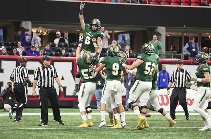 After Ryan Davis catches and scores a 36-yard touchdown in the fourth quarter, Blessed Trinity High School center Jackson Filipowicz (#53) lifts Davis in the air above elated teammates. It gave the team a 16-6 lead with just over 9:00 remaining in the game. Blessed Trinity would eventually defeat Cartersville High School 23-9 to earn the moniker, âback-to-back state champion.â Davis was also named the gameâs Most Valuable Player. Photo By Michael Alexander