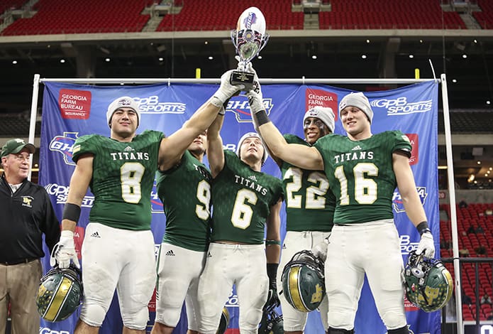 (L-r) Blessed Trinity High School head football coach Tim McFarlin watches as defensive end Jr. Bivens (#8), quarterback Jake Smith (#9), wide receiver Ryan Davis (#6), running back Steele Chambers (#22) and middle linebacker JD Bertrand (#16) hoist the championship during the post-game presentation. Photo By Michael Alexander