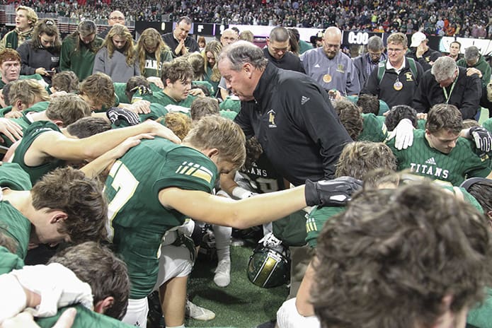 “First thing first,” said head coach Tim McFarlin, center, as he gathered the team in a circle for a post-game prayer before the trophy presentation. Photo By Michael Alexander