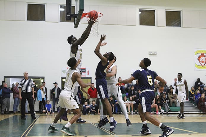 With his six-foot, eight-inch frame, Holy Spirit Prep center Ibrahima Jarjou (#22) goes high above the opposition to grab a rebound during the team's Dec. 14 home game. Photo By Michael Alexander