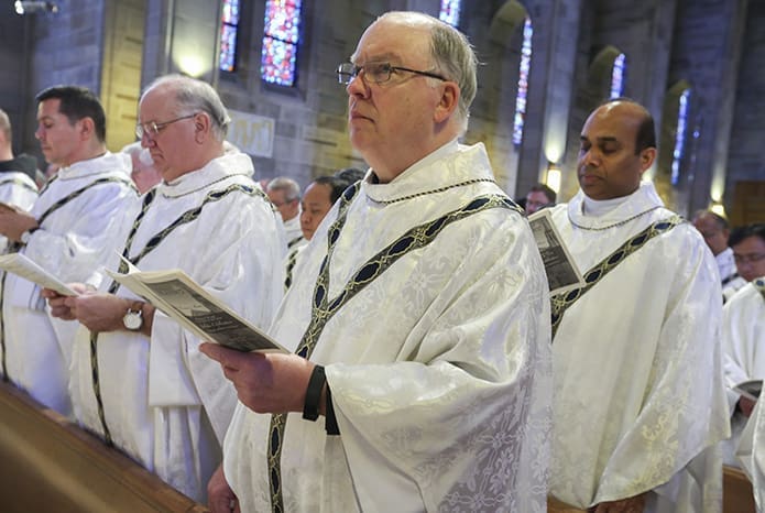 (R-l) Father Jojohn Chettiyakunnel, MS, parochial vicar at Saint Thomas the Apostle Church, Smyrna, Father Dan Stack, pastor of St. Thomas Aquinas Church, Alpharetta, Father Paul Flood, pastor of St. Benedict Church, Johns Creek, and Father Javier Muñoz, parochial vicar at Immaculate Heart of Mary Church, Atlanta, join their brother clergy in the renewal of their priestly commitment during the annual Chrism Mass at the Cathedral of Christ the King, Atlanta. Photo By Michael Alexander