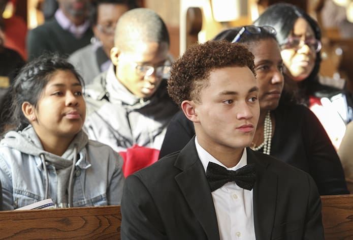 Junior Knights of Peter Claver Nathan Haydel, foreground, a member of Our Lady of Lourdes Church, Atlanta, sits among the congregation at the Shrine of the Immaculate Conception, Atlanta, during the 2018 Dr. Martin Luther King Jr. Eucharistic Celebration. Haydel is also a freshman at Our Lady of Mercy High School, Fayetteville. Photo By Michael Alexander