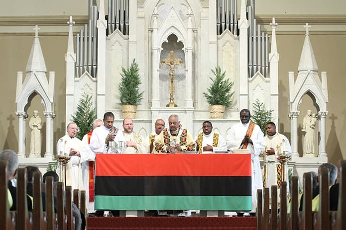 Archbishop Wilton D. Gregory, center, the liturgy’s principal celebrant, joins his brother clergy at the altar during the Liturgy of the Eucharist. Photo By Michael Alexander