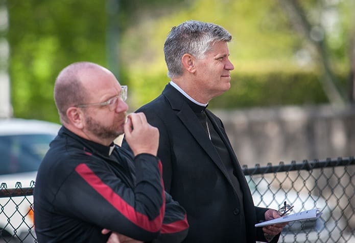 Father Victor Galier, pastor of St. Anthony of Padua Church in Atlanta, left, and Bishop Bernard E. Shlesinger III listen to a reflection at the ecumenical Good Friday Pilgrimage March 30. Photo By Thomas Spink