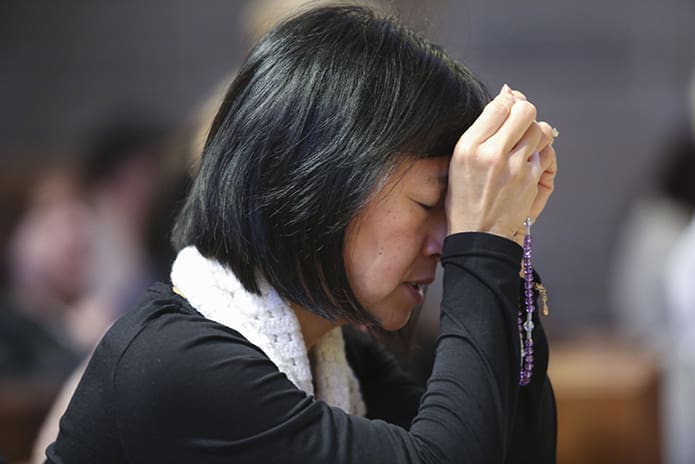 Sharon Mai of St. Benedict Church, Johns Creek, joins the congregation in praying the joyful mysteries of the rosary prior to the Mass for the Unborn. Photo By Michael Alexander.