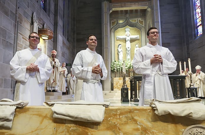 After the ordination candidates were called for service to the priesthood, during the June 16 rite of ordination, all five of them, including (l-r) Rev. Mr. Michael Bremer, Rev. Mr. Brian McNavish and Rev. Mr. Michael Metz, turned to face the upbeat applause of the congregation at the Cathedral of Christ King, Atlanta. Photo By Michael Alexander
