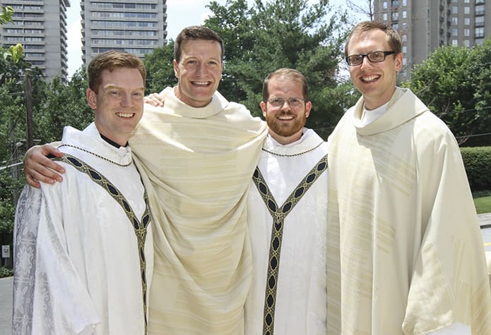 (L-r) Father Connor Danstrom of Chicago, Ill., Father Michael Metz, Father Rob Johnson of Springfield, Ill., and Father Michael Bremer pose for a post ordination photograph in front of the Cathedral of Christ King, Atlanta. Metz and Bremer attended Mundelein Seminary, which is some 40 miles north of Chicago. Photo By Michael Alexander