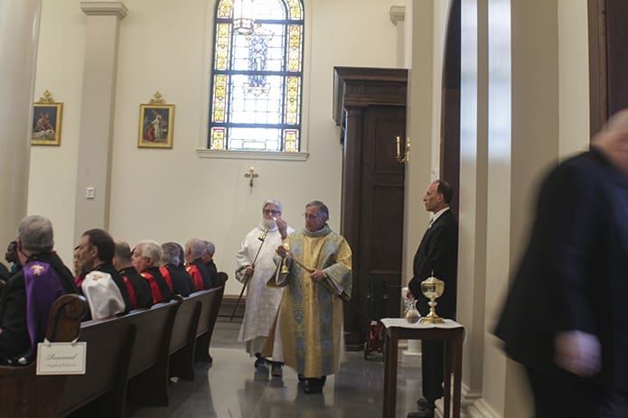 Deacon Bill Boyd of Mary Our Queen Church, right, and Deacon Robb Ciezki of the Diocese of Buffalo, left, lit the candles along the walls of the church and on the altar during the March 17 Mass of Dedication. Photo By Deacon Ken Melvin