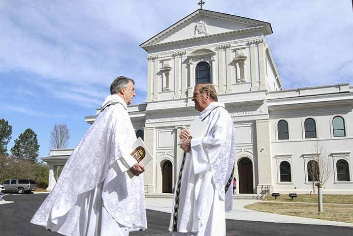 Father David M. Dye, left, the retired administrator of Mary Our Queen Church, Norcross, and Father Francis “Butch” Mazur, the last pastor of St. Gerard Church, Buffalo, New York, discuss the new Mary Queen Church in the background, which was built as a replica of St. Gerard. Photo By Michael Alexander