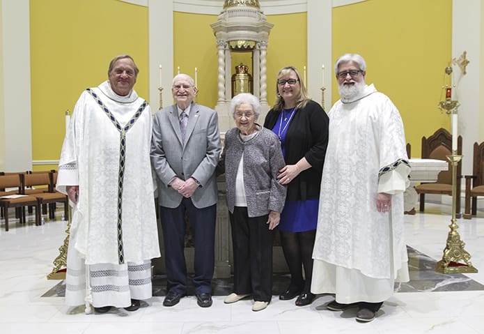(L-r) Father Francis “Butch” Mazur, the last pastor of St. Gerard Church, Buffalo, New York, Richard and Dorothy Ciezki, their daughter-in-law Frankie, and son Deacon Robb Ciezki of the Diocese of Buffalo pose for photo in front of the altar and tabernacle at Mary Our Queen Church, two of the many artifacts that came from St. Gerard Church when it closed in 2008. Deacon Ciezki served at St. Gerard and his family held membership there at time of its closing. Photo By Michael Alexander