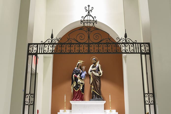 The two statues Mary and Jesus and Joseph appeared on opposite sides of the church in the old Mary Our Queen worship space. In the new church, the Holy Family occupies the same side altar. The iron gates in front of the altar came from St. Gerard Church in Buffalo, New York. Photo By Michael Alexander
